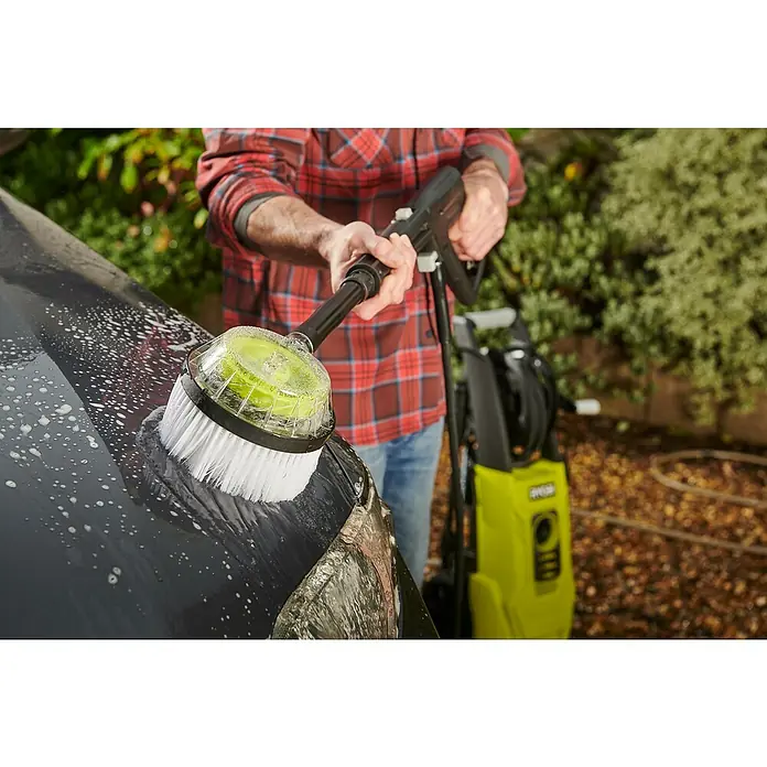 Ryobi Reinigungsbürste RAC 785 - Ausstattung: Borsten - Nahaufnahme einer Person, die ein Auto mit einer rotierenden Bürste und einem Ryobi-Hochdruckreiniger reinigt.