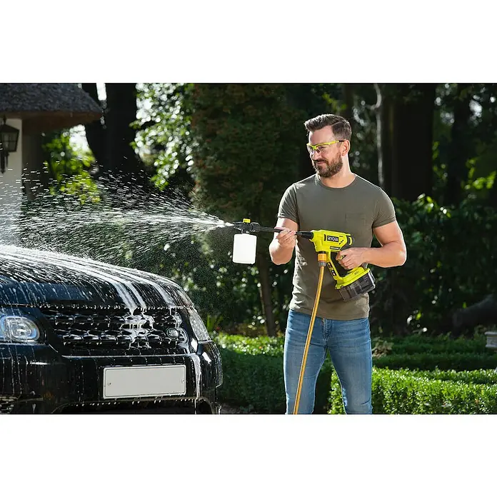 Ryobi Spritzflasche - 750 ml, Kunststoff - Mann wäscht ein Auto mit einem gelben RYOBI Akku-Hochdruckreiniger im Freien, Spritzwasser ist zu sehen.