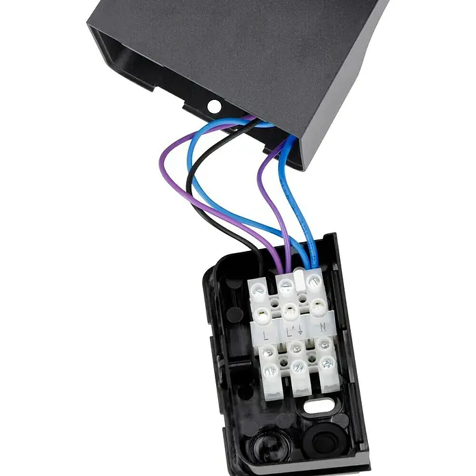 Steinel LED-Sensor-Strahler XLED home 2 S graphit - 13,7 W, L x B x H: 161 x 180 x 218 mm, Graphit, IP44 - Nahaufnahme eines elektrischen Anschlusskastens mit sichtbaren blauen, violetten und schwarzen Drähten, die mit den Klemmen verbunden sind.