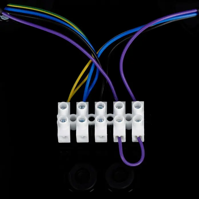 Steinel LED-Sensor-Außenwandleuchte Spot Duo S anthrazit - 14,95 W, L x B x H: 9,8 x 24,7 x 17,5 cm, Anthrazit, Warmweiß - Nahaufnahme einer Lüsterklemme mit farbigen Kabeln, die an einem schwarzen Hintergrund befestigt sind. Das Produkt ist für elektrische Verbindungen.