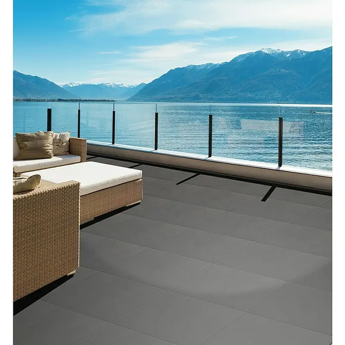 Terrassenfliese Garden Family Grey - 60 x 60 x 2 cm, Grau, Matt - Terrasse mit grauen Bodenfliesen und Sitzmöbeln mit Blick auf einen See und Berge. Die Bodenfliesen sind robust und stilvoll.