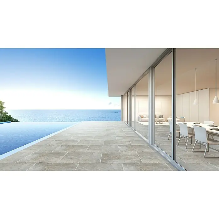 Terrassenfliese Manchester 2.0 - 60 x 60 x 2 cm, Grau, Matt - Sonnenverwöhnter Wohnraum mit eleganten, raumhohen Fensterfronten, der nahtlos in eine Terrasse mit Pool und Meerblick übergeht.
