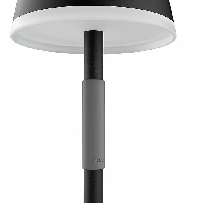 Philips Hue Akku-Tischleuchte Go Portable - 6,2 W, L x B x H: 21,9 x 20,9 x 38,8 cm, Mehrfarbig, Schwarz - Nahaufnahme einer Philips Hue Stehleuchte mit schwarzem Lampenschirm und grauem Ständer, ideal für stimmungsvolle Beleuchtung.