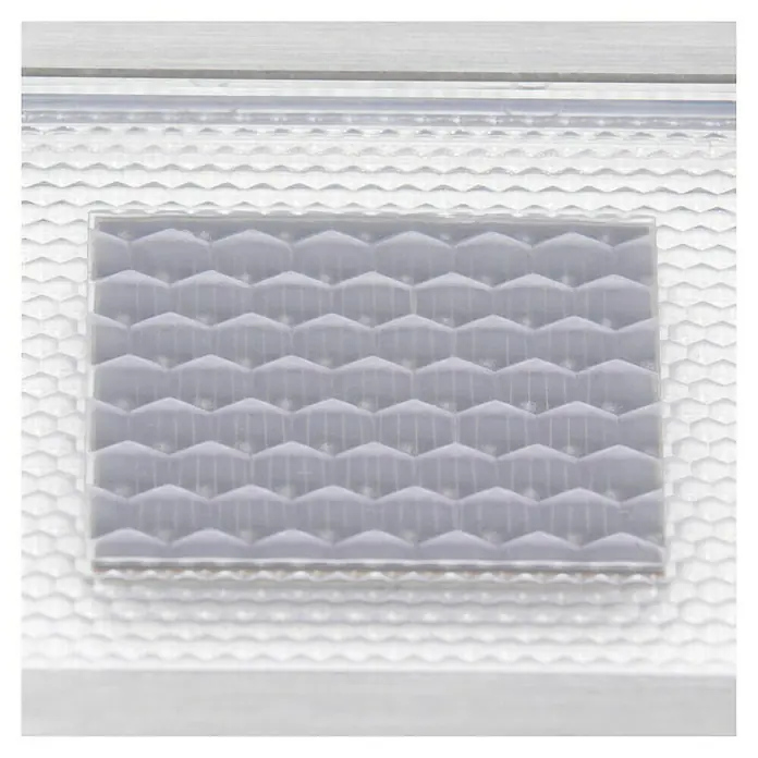 Paulmann LED-Außenwegleuchte Cube - Warmweiß, L x B x H: 10 x 10 x 4,5 cm - Nahaufnahme eines transparenten Kunststoffformteils mit einem regelmäßigen, sechseckigen Muster, das Licht brechen und streuen kann.