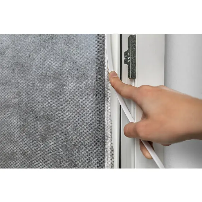 Schellenberg Mosquitera EasyClick - An x Al: 130 x 150 cm, Montaje de la mosquitera: Pegado, Color bastidor: Blanco - Primer plano de una persona instalando burletes blancos en un marco de ventana para mejorar el aislamiento.