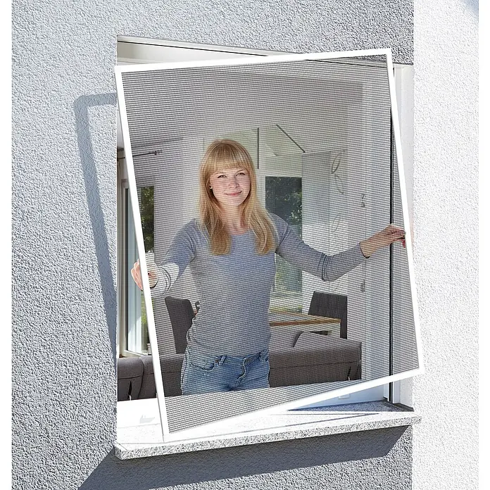 Schellenberg Mosquitera Action - An x Al: 120 x 140 cm, Montaje de la mosquitera: Inserción, Color bastidor: Blanco - Una mujer instala una mosquitera blanca en una ventana. La mosquitera mantiene alejados a los insectos y deja entrar aire fresco.
