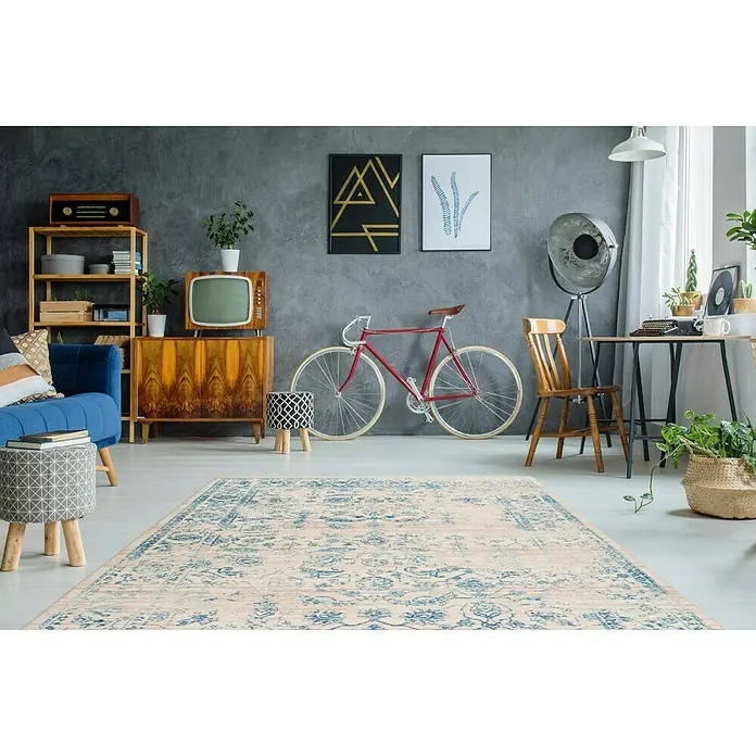 Kayoom Kurzflorteppich Baroque I - Creme/Blau, 150 x 80 cm, 100 % Polyester - Ein stilvoller Raum mit einem gemusterten Teppich in der Mitte, umgeben von Möbeln und Dekorationen.