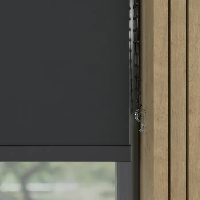 Expo Ambiente Verdunkelungsrollo Mila - B x H: 150 x 190 cm, Schwarz - Nahaufnahme einer grauen Rollgardine mit Kettenzug vor einer Holzwand, die modernes Design und Funktionalität vereint.