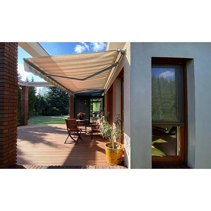 SM Gelenkarmmarkise REC-089 - Hellgrau/Grau, Farbe Gestell: Weißaluminium, Breite: 3,6 m, Ausfall: 2,5 m - Außenansicht eines Hauses mit einer ausfahrbaren Markise über einer Terrasse mit Gartenmöbeln. Die Markise bietet Schatten und Schutz.