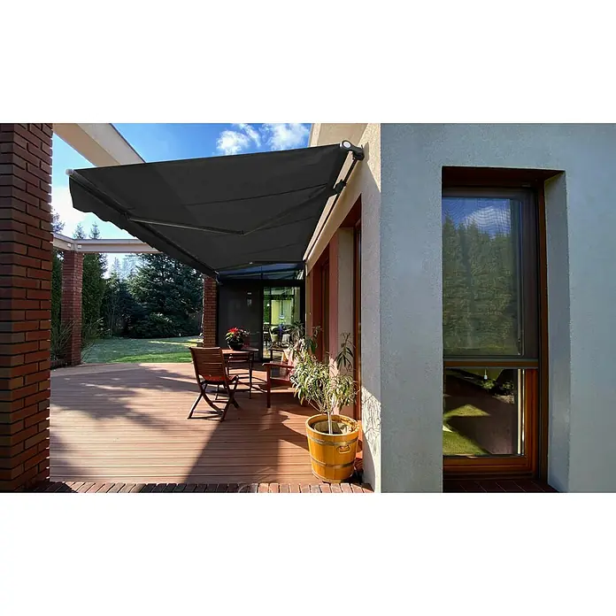 SM Gelenkarmmarkise REC-164 - Dunkelgrau, Farbe Gestell: Anthrazitgrau, Breite: 3,6 m, Ausfall: 2,5 m - Eine graue Markise spendet Schatten auf einer Terrasse mit Tisch und Stühlen, daneben ein Fenster und eine Pflanze in einem Topf.
