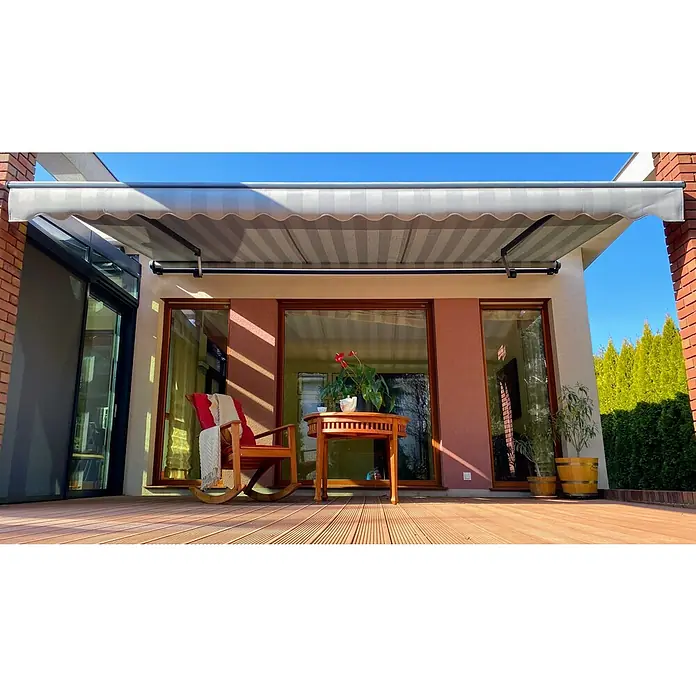 SM Gelenkarmmarkise REC-089 - Hellgrau/Grau, Farbe Gestell: Anthrazitgrau, Breite: 5 m, Ausfall: 3 m - Ansicht einer ausfahrbaren, gestreiften Markise, die Schatten auf eine Holzterrasse mit Sitzbereich wirft. Der perfekte Sonnenschutz!