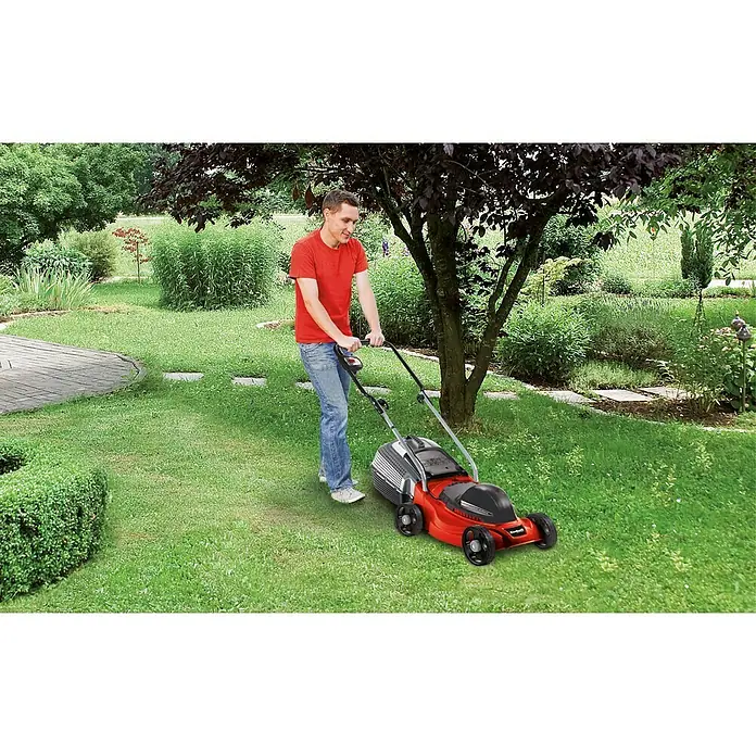 Einhell Elektro-Rasenmäher GC-EM 1030/1 - 1.000 W, Schnittbreite: 30 cm - Mann mäht Rasen mit einem roten Rasenmäher in einem gepflegten Garten mit Bäumen und Sträuchern.