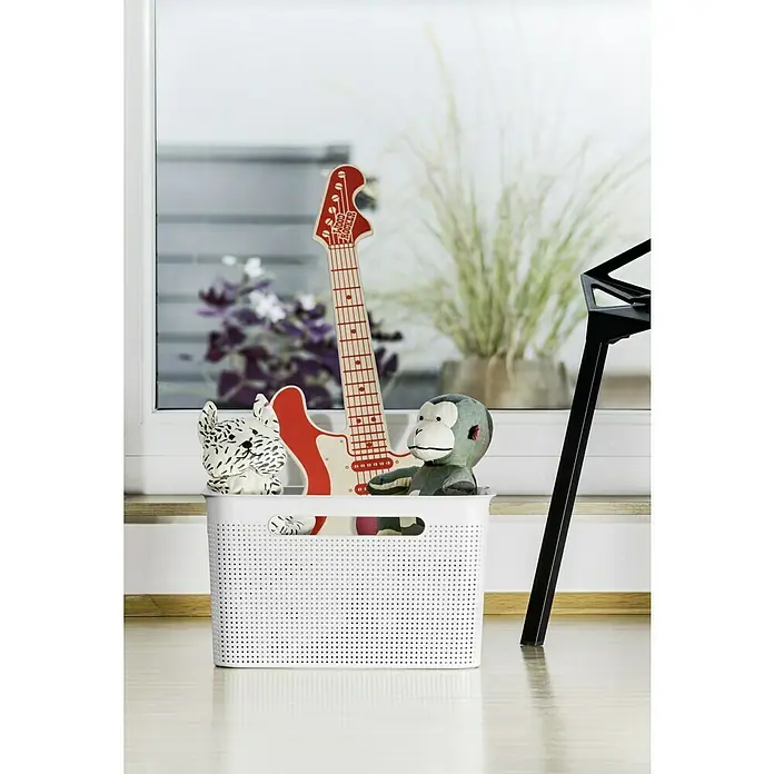 Rotho Aufbewahrungsbox Brisen - L x B x H: 36 x 26,2 x 21,1 cm, Kunststoff, Weiß - Spielzeugaufbewahrung: Ein weißer Korb mit Spielzeug wie einer Gitarre und einem Stofftieraffen vor einem Fenster.