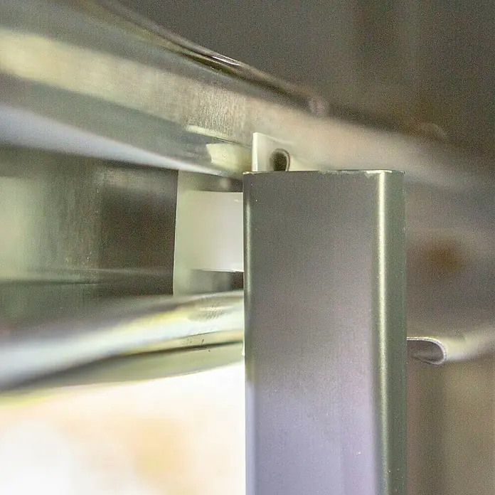 Spacemaker Gerätehaus 5x4 - Außenbreite inkl. Dachüberstand: 151 cm, Außentiefe inkl. Dachüberstand: 122 cm, Stahl, Grau - Die Aufnahme zeigt eine Nahaufnahme eines Metallrahmens mit einem weißen Kunststoffstück, möglicherweise Teil eines Möbelstücks oder einer Struktur.