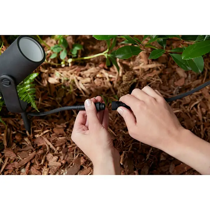 Philips Hue Verlängerungskabel White and Color Ambiance Outdoor - 5 m, Schwarz, IP67 - Verbindung von zwei Teilen eines schwarzen Outdoor-Lichtkabels.