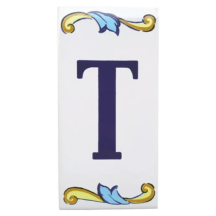 Pavimento cerámico Letra T - 7,5 x 15 cm, Blanco/Azul/Amarillo, Brillante - Azulejo de cerámica con la letra T, adornado con elementos florales en amarillo y azul, ideal para diseños de pared personalizados.