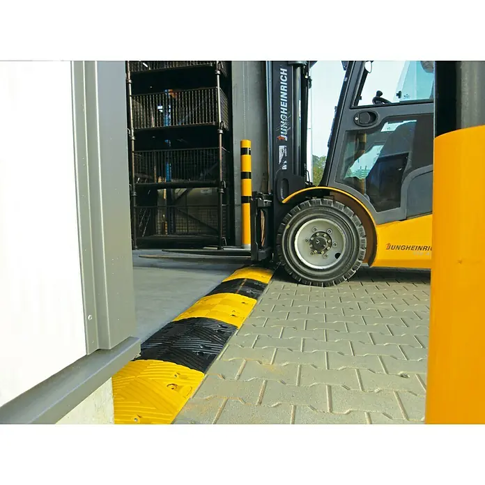 Schake Bodenschwelle Mittelstück NOX - L x B: 500 x 430 mm, Höhe: 60 mm, Farbe: Schwarz, Kunststoff - Ein gelber Gabelstapler von Jungheinrich steht auf einem Lager mit einer schwarz-gelben Bremsschwelle am Boden.