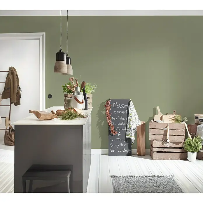 A.S. Création Greenery Vliestapete - Olivgrün, Uni, 10,05 x 0,53 m - Küchenszene mit Kreidetafel, Hängelampen, Kücheninsel und Holzkisten, die eine gemütliche und rustikale Atmosphäre schaffen.