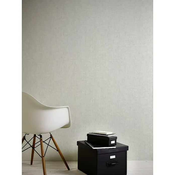A.S. Création Greenery Vliestapete Strukturuni - Grau, Uni, 10,05 x 0,53 m - Nahaufnahme von schwarzen Aufbewahrungsboxen und einem weißen Stuhl vor einer grauen Wand, die Textur und Organisation zeigt.