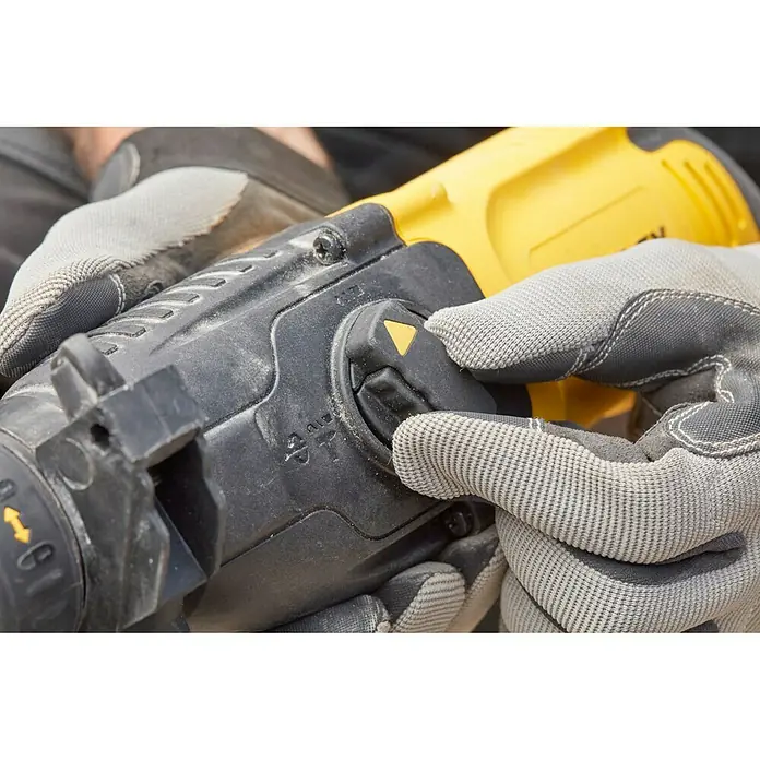 Stanley FatMax Martillo combinado SFMEH200K-QS - 750 W, 2,2 J, Alojamiento SDS-Plus - Un martillo perforador inalámbrico en acción, operado por manos con guantes de trabajo. Centrado en la herramienta eléctrica amarilla.
