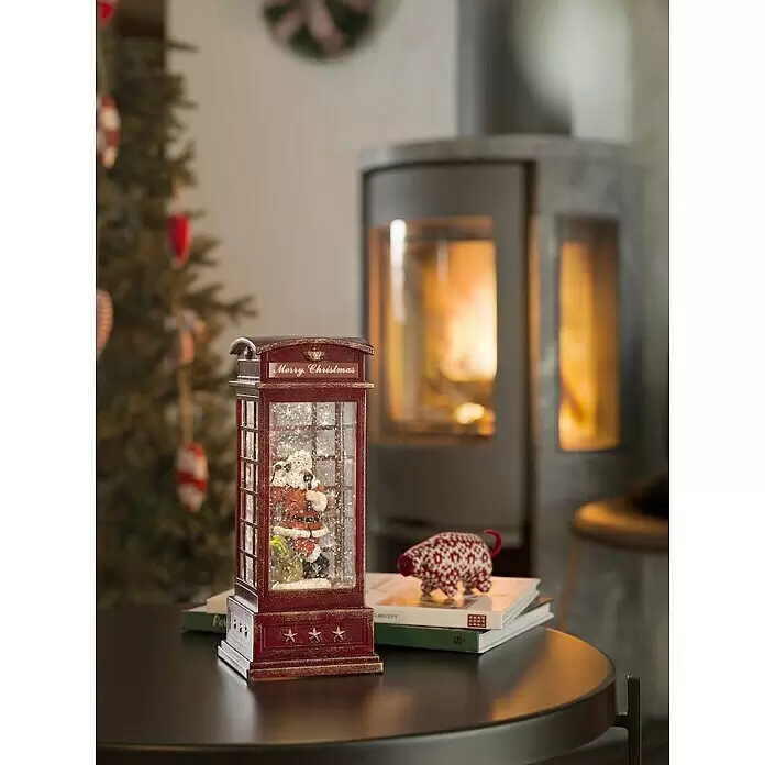 Konstsmide LED-Weihnachtsdekoleuchte Telefonzelle - 10,5 mm x 10,5 cm x 25 cm, Rot, LED, Weihnachtsmann - Rote Telefonzellen-Schneekugel mit Weihnachtsmann und Goldakzenten auf dunklem Tisch als Weihnachtsdeko.