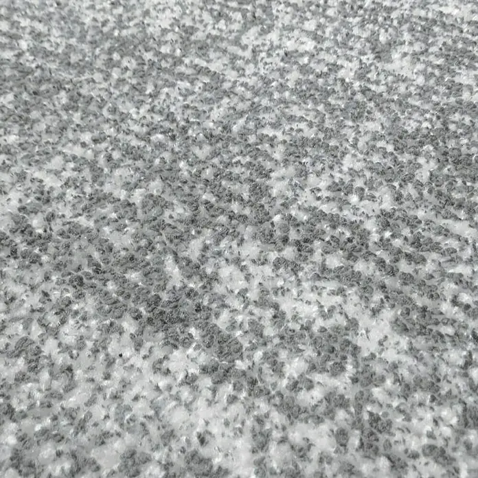 Kayoom Kurzflorteppich Etna - Grau/Silber, 290 x 200 cm, 100 % Mikropolyester - Nahaufnahme einer texturierten grauen Oberfläche, die an zerkleinertes Material oder feinen Schutt erinnert.\n