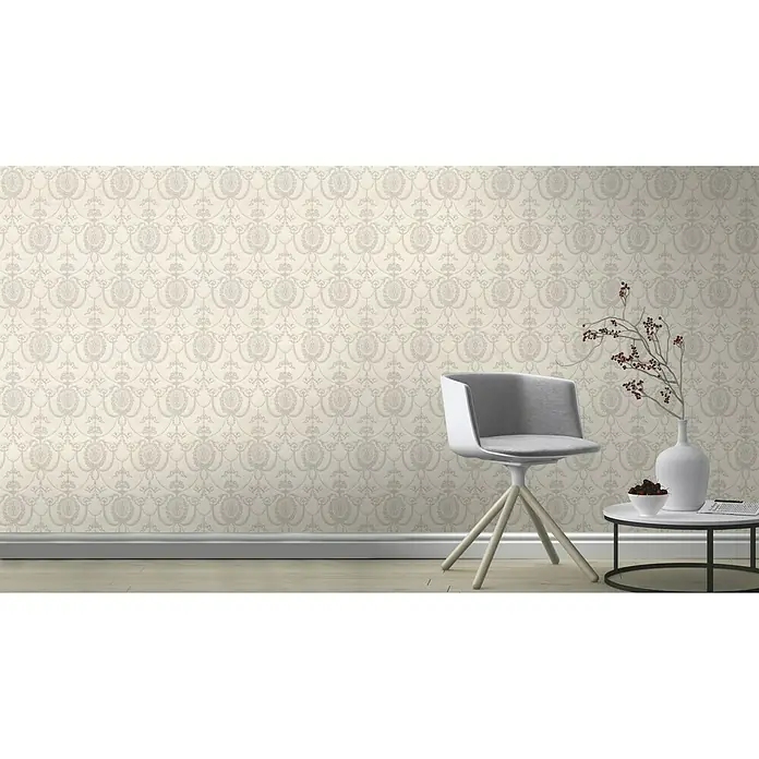 Rasch Trianon Vliestapete II - Altrosé, Ornament, 10,05 x 0,53 m - Einrichtungsszene mit einer eleganten grauen Tapete mit floralem Muster, einem modernen Stuhl und einem kleinen Tisch.