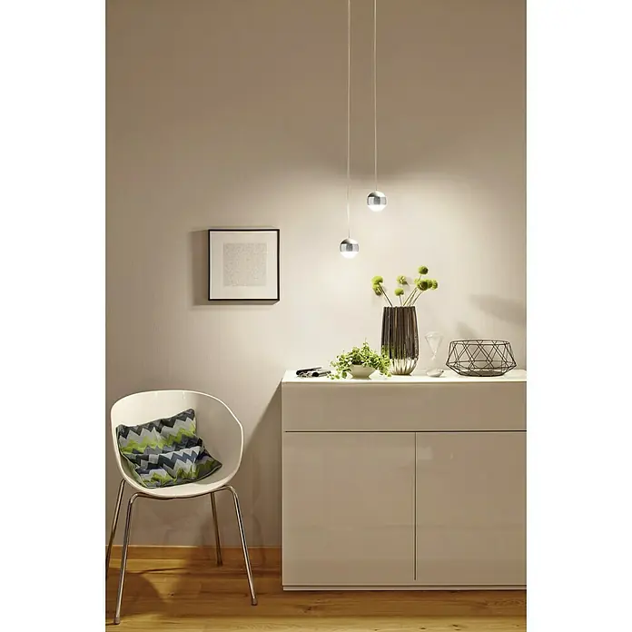 Paulmann URail LED-Pendelleuchte Capsule II - Warmweiß, Chrom, Ø x H: 8,7 x 130 cm - Elegantes Interieur mit einer weißen Kommode, dekorativen Elementen und zwei modernen, hängenden Kugelleuchten, die ein sanftes Licht spenden.