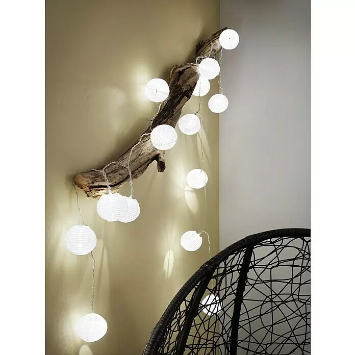 Paulmann Guirnalda luminosa LED Lampion - 3,6 m, Para exterior - Guirnalda de luces de papel blanco sobre madera natural en la pared, creando una iluminación ambiental suave.
