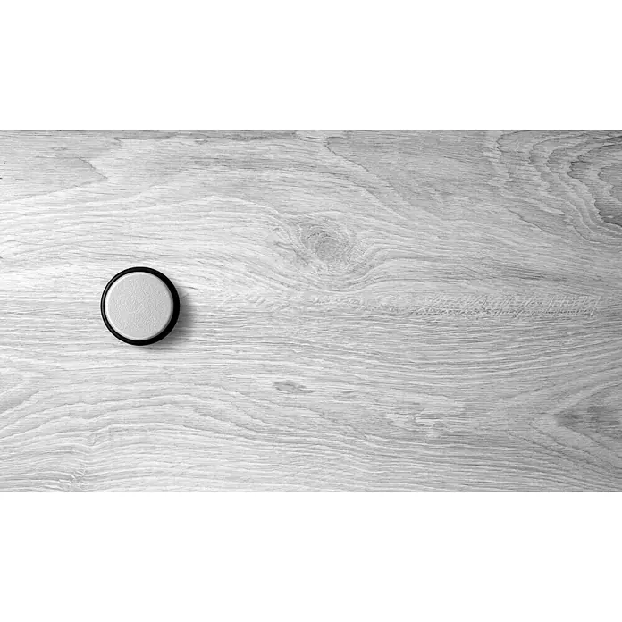 Inofix Tope de puerta 2098 - Ø x Al: 46 x 18 mm, Cromo - Una sola batería de pila de botón sobre una superficie de madera clara, ideal para pequeños dispositivos electrónicos.
