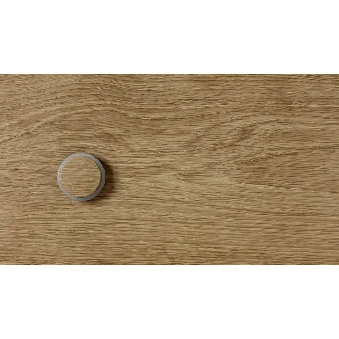 Inofix Tope de puerta 2098 - Ø x Al: 46 x 18 mm, Nogal Americano - Primer plano de un AirTag sobre una mesa de madera clara, combinando estilo minimalista con tecnología moderna.