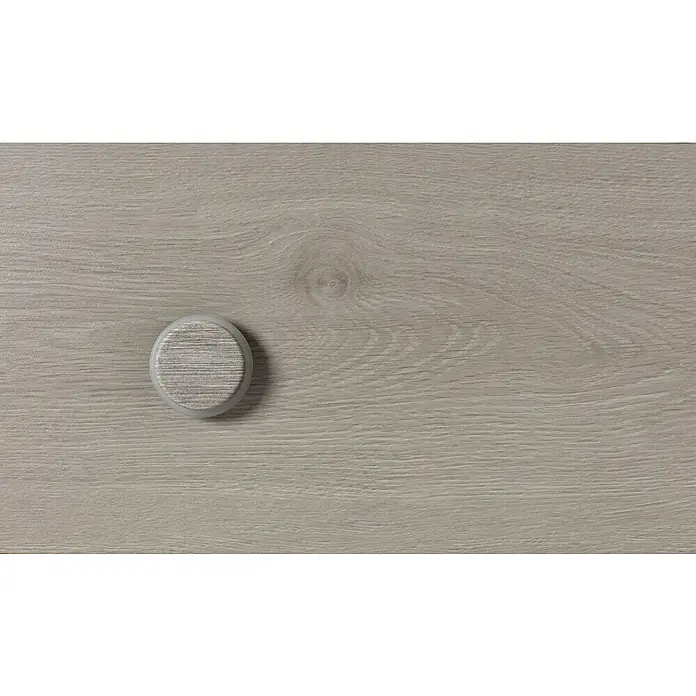 Inofix Tope de puerta 2098 - Ø x Al: 46 x 18 mm, Arce Nórdico - Un primer plano de un tirador de cajón gris claro sobre una superficie de madera, irradiando elegancia sencilla.