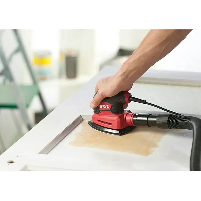 Skil Elektro-Multischleifer 7260 AA - 100 W, Leerlaufschwingzahl: 24.000 U/min, Durchmesser Schwingkreis: 1,6 mm - Nahaufnahme des SKIL-Deltaschleifers in Aktion, der für feine Schleifarbeiten verwendet wird und Staub absaugt. Ideal für DIY-Projekte.