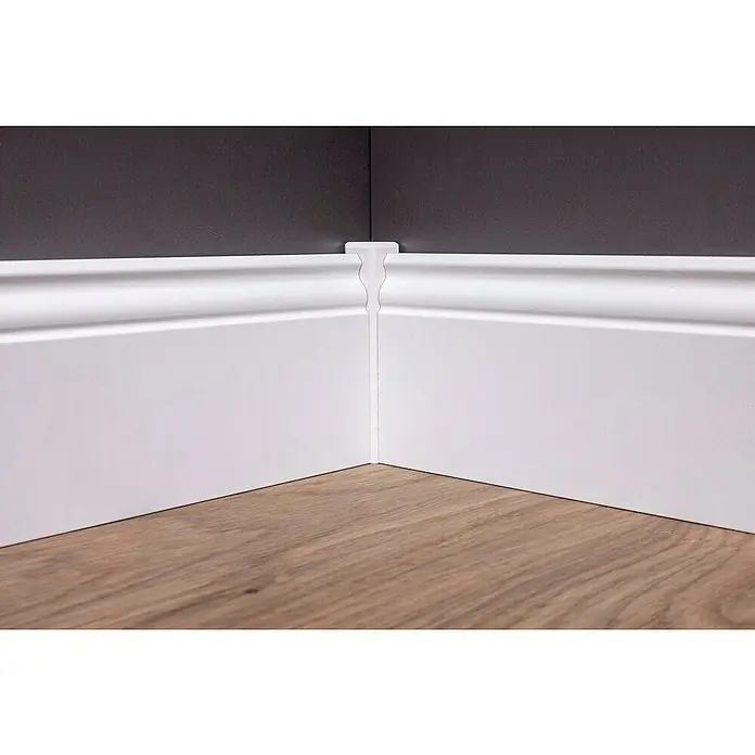 Sockelleiste - 240 x 1,9 x 10 cm, MDF, Profiliert - Das Bild zeigt eine weiße Eckleiste, die an einer Wand und einem Boden befestigt ist. Die Leiste ist sauber verarbeitet und verleiht dem Raum ein elegantes Aussehen.