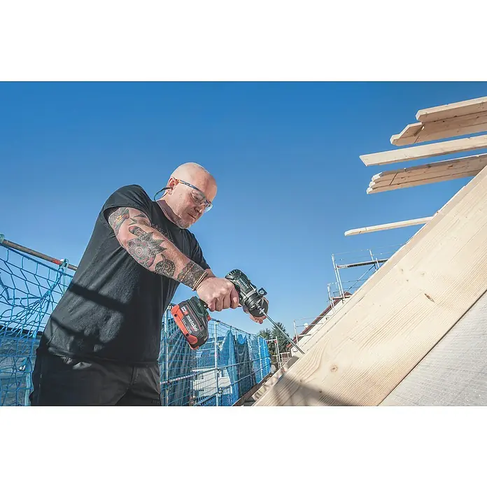 Metabo CAS 18V Akku-Bohrschrauber BS 18 LTX BL Q I - 18 V, 2 Akkus, 5,5 Ah, 130 Nm - Ein Handwerker mit Metabo Akku-Bohrschrauber bei der Arbeit an einem Dachstuhl, professionell und zuverlässig.