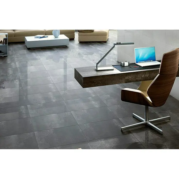Azteca Feinsteinzeugfliese Cosmos Lux - L x B: 60 x 60 cm, Negro - Innenraum mit glänzenden grauen Bodenfliesen, Büromöbeln und Sofa. Elegantes Design mit moderner Ästhetik.