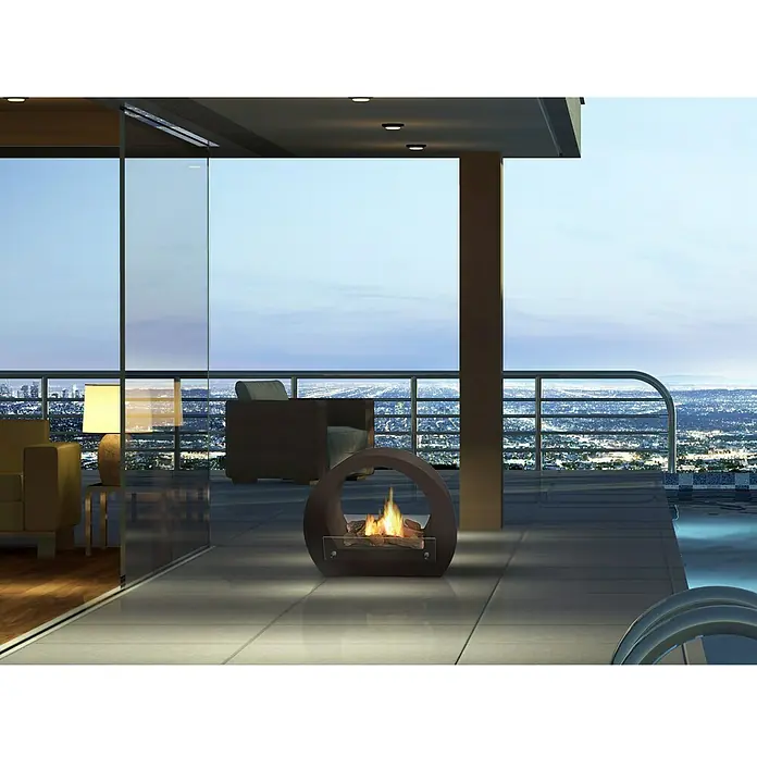 Purline Chimenea de bioetanol Saturn B - 23 x 64 x 52 cm, Negro - Moderna chimenea exterior en un patio con vistas a una ciudad de noche. La chimenea tiene un diseño redondo único y está encendida.