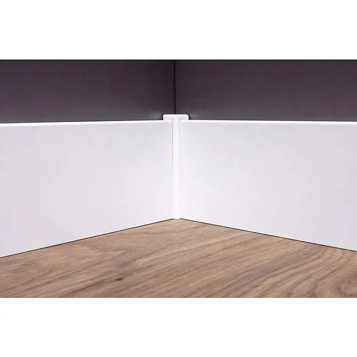 Sockelleiste - 240 x 1,6 x 10 cm, MDF - Detailaufnahme einer Ecke mit weißen Fußleisten, die durch ein Verbindungsstück perfekt zusammengefügt sind und einen sauberen Übergang zum Boden bilden.