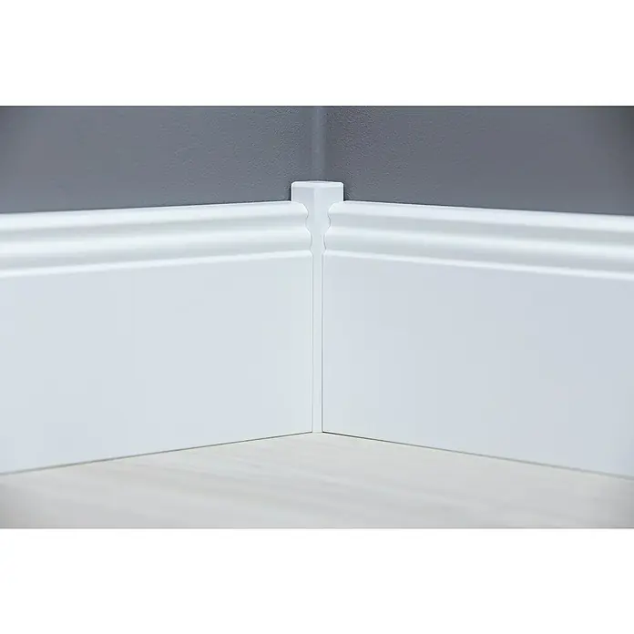 Sockelleiste - 244 x 1,8 x 11,5 cm, MDF - Eckansicht einer weißen Sockelleiste, die eine saubere und elegante Verbindung zwischen Wand und Boden bildet. Die Leiste ist sorgfältig verarbeitet.
