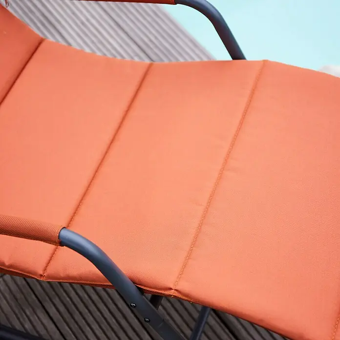 Siena Garden Garten-Schaukelliege AlianoRot, L x B x H: 143 x 57 x 84 cm, Stahl, Pulverbeschichtet - Nahaufnahme eines orangefarbenen Liegestuhls mit grauem Rahmen. Bequeme Sitzgelegenheit für den Außenbereich zum Entspannen am Pool oder im Garten.