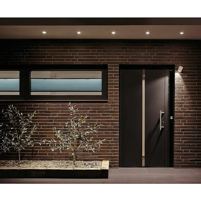 Paulmann Nova LED-Einbauleuchte rund Plus - 35 W, Ø x H: 9,3 x 4,5 cm, Eisen gebürstet - Eine moderne Haustür mit Edelstahlgriff und stilvoller Beleuchtung an einer Backsteinwand mit Fenster.