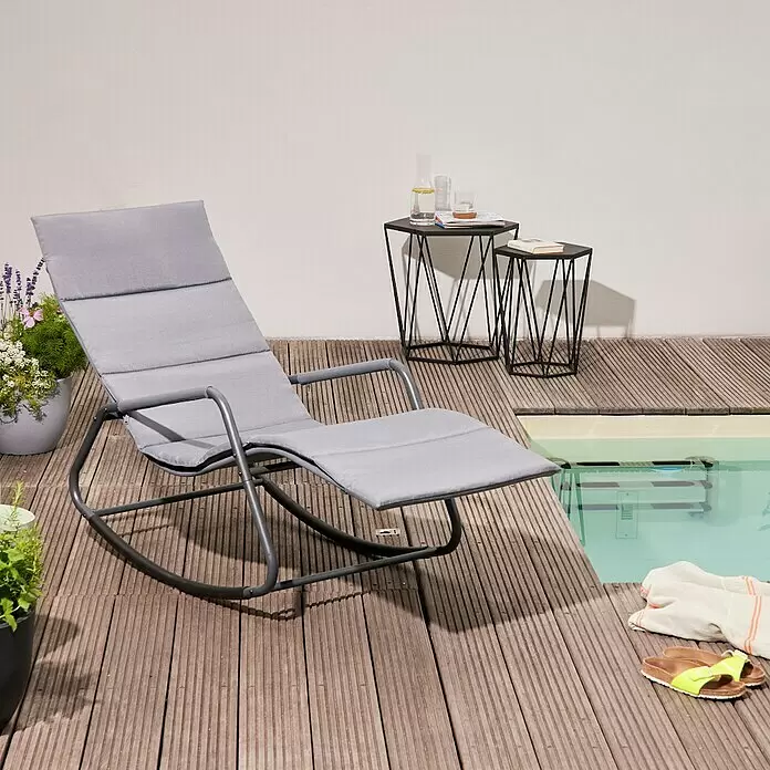 Siena Garden Gartenliege Aliano - Grau, Stahl, Pulverbeschichtet - Grauer gepolsterter Schaukel-Liegestuhl auf einer Holzterrasse am Pool, mit schwarzen geometrischen Beistelltischen.