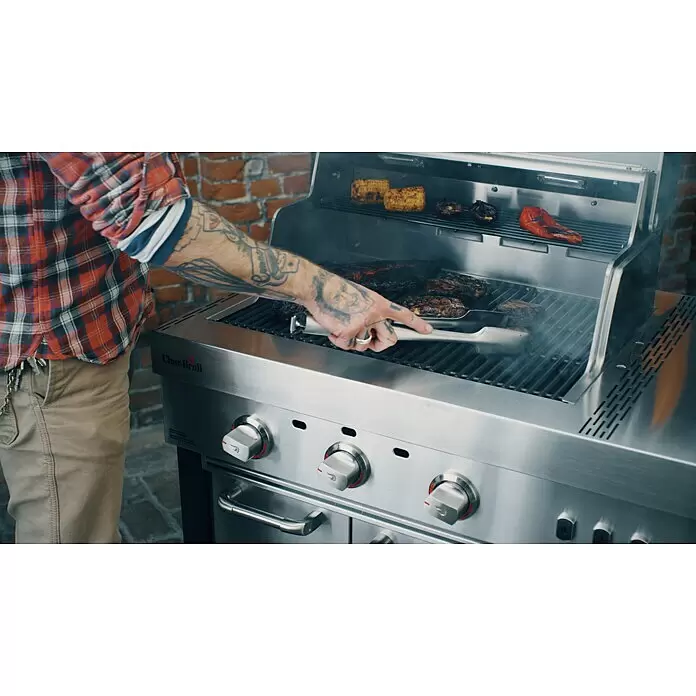 Char-Broil Outdoorküchen-Modul Ultimate 3200 - Silber, B x T x H: 100,3 x 67,3 x 120 cm, Edelstahl - Person grillt Fleisch, Mais und Gemüse auf einem Char-Broil Gasgrill aus Edelstahl mit Zange.
