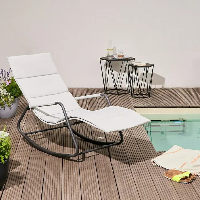 Siena Garden Garten-Schaukelliege AlianoHellgrau, L x B x H: 143 x 57 x 84 cm, Stahl, Pulverbeschichtet - Ein stilvoller, weißer Liegestuhl aus Metall neben einem erfrischenden Pool, ergänzt durch Beistelltische und dekorative Elemente.
