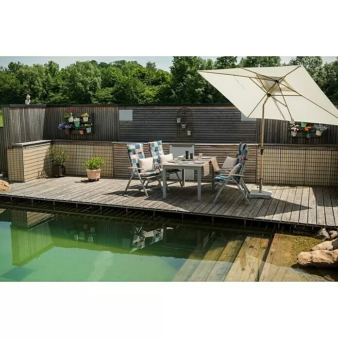 Doppler Alu Wood Marktschirm Ultra - Natur, Bespannungsmaß (L x B): 300 x 200 cm - Outdoor-Esstisch und Stühle mit gemusterten Auflagen auf Holzterrasse am Pool, beschattet von einem cremefarbenen Sonnenschirm.