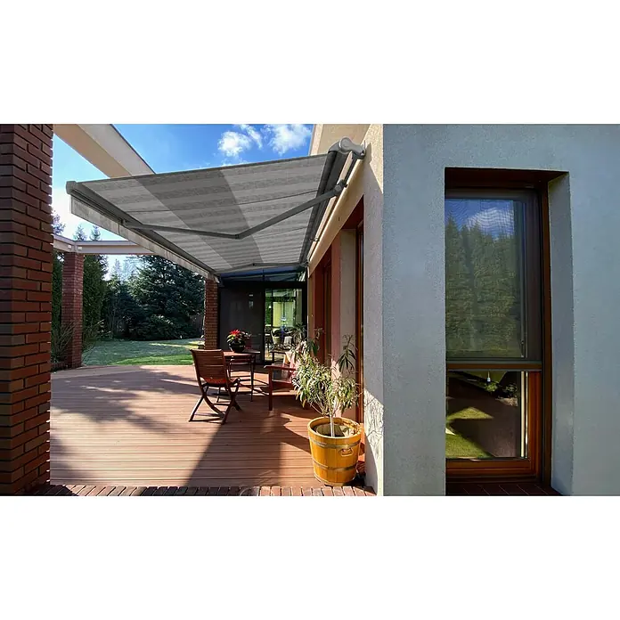 SM Hülsenmarkise REC-089 - Hellgrau/Grau, Farbe Gestell: Weißaluminium, Breite: 3,6 m, Ausfall: 2,5 m - Eine moderne Terrassenmarkise mit Streifenmuster spendet Schatten auf einer Holzterrasse mit Tisch und Stühlen.