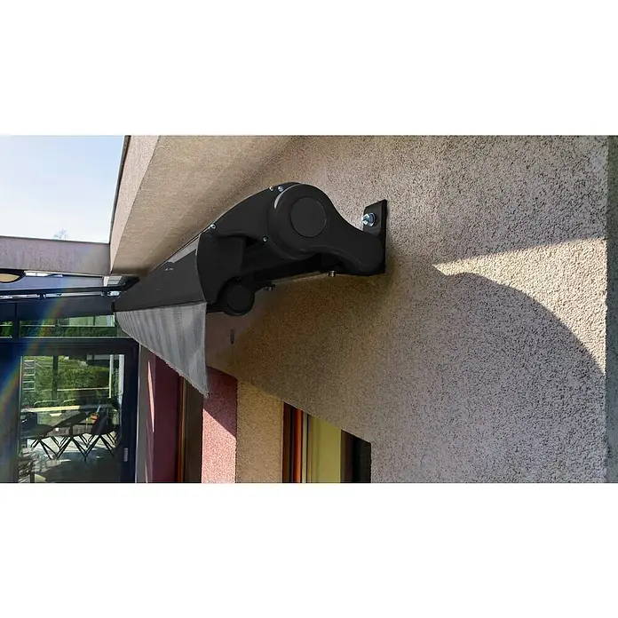 SM Hülsenmarkise REC-089 - Hellgrau/Grau, Farbe Gestell: Anthrazitgrau, Breite: 5 m, Ausfall: 3 m - Eine Nahaufnahme einer Markise, die an einer Wand befestigt ist, mit einem hervorstechenden schwarzen Gehäuse und grauem Stoff.