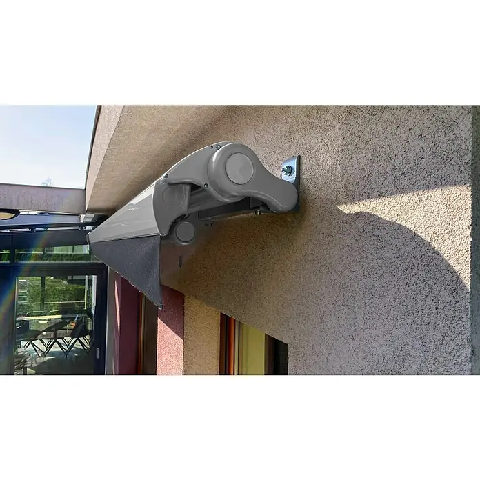 SM Hülsenmarkise REC-164 - Dunkelgrau, Farbe Gestell: Weißaluminium, Breite: 3,6 m, Ausfall: 2,5 m - Nahaufnahme einer eleganten, grauen Markise an einer Fassade, die Funktionalität und modernes Design vereint.