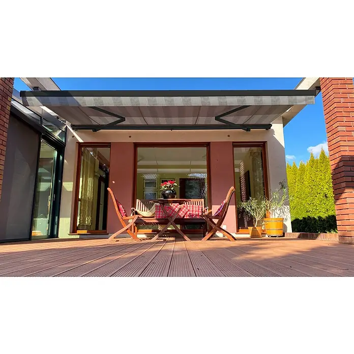 SM Hülsenmarkise REC-089 - Hellgrau/Grau, Farbe Gestell: Anthrazitgrau, Breite: 5 m, Ausfall: 3 m - Terrasse mit Markise und Möbeln. Die graue Markise schützt den Sitzbereich vor der Sonne und bietet einen angenehmen Schattenplatz im Freien.