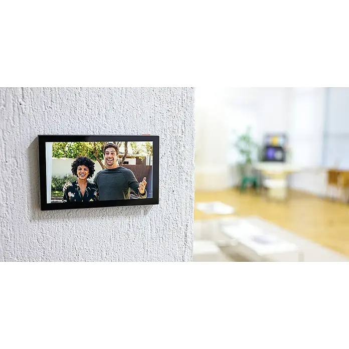 EZVIZ Farb-Video-Türsprechanlage HP7 - 2-Draht-Technik, Bildschirmgröße: 7 ", 1.024 x 600 Pixel - Intelligenter Bildschirm an einer Wand, der ein Paar zeigt, mit einem stilvollen, verschwommenen Hintergrund, der das moderne Design hervorhebt.